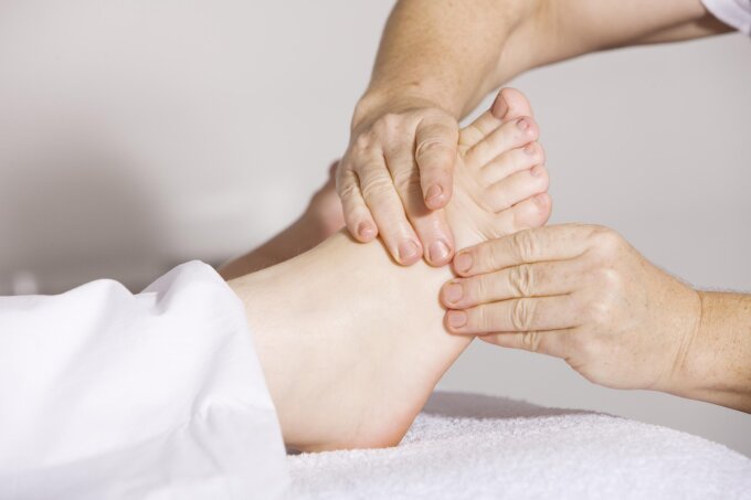 Relaxing reflexology treatment with hands gently pressing the sole of a foot